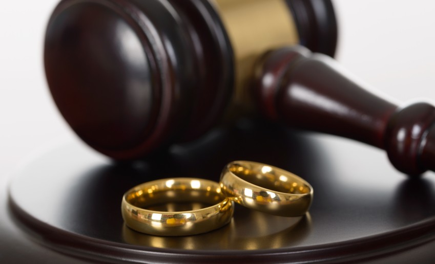 Close-up Of Wedding Rings And Wooden Gavel